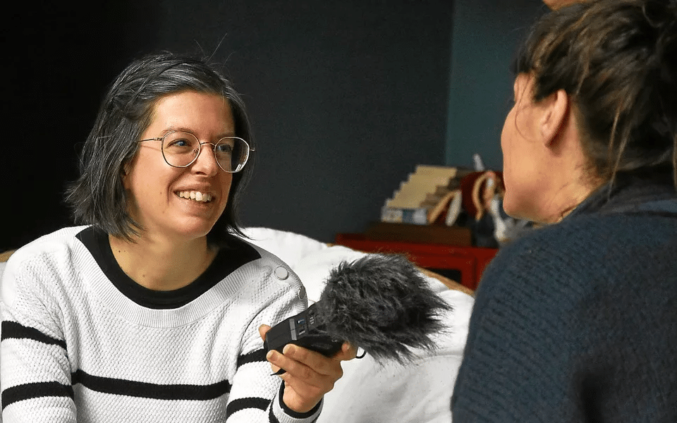 Laura Heulard en plein enregistrement sonore lors d’un reportage Mémoire Vive, captant des souvenirs et des voix dans un cadre intime.